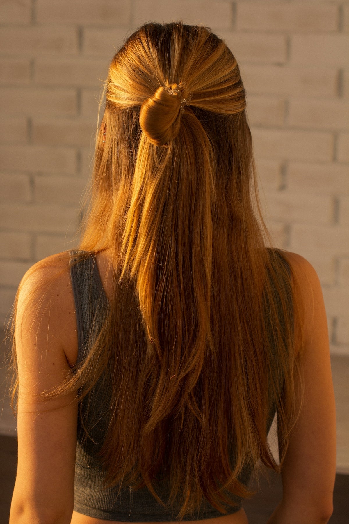 woman in black tank top with brown hair tie